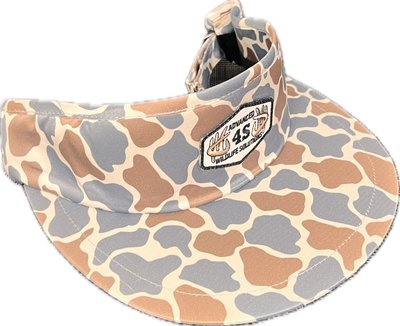 A beige, gray, and brown camouflage tall visor with an adjustable buckle and a white hexagon patch on the front.
